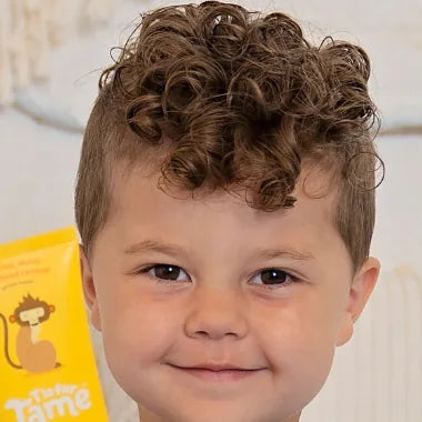 After: the same boy, a tube of Taming Cream beside him