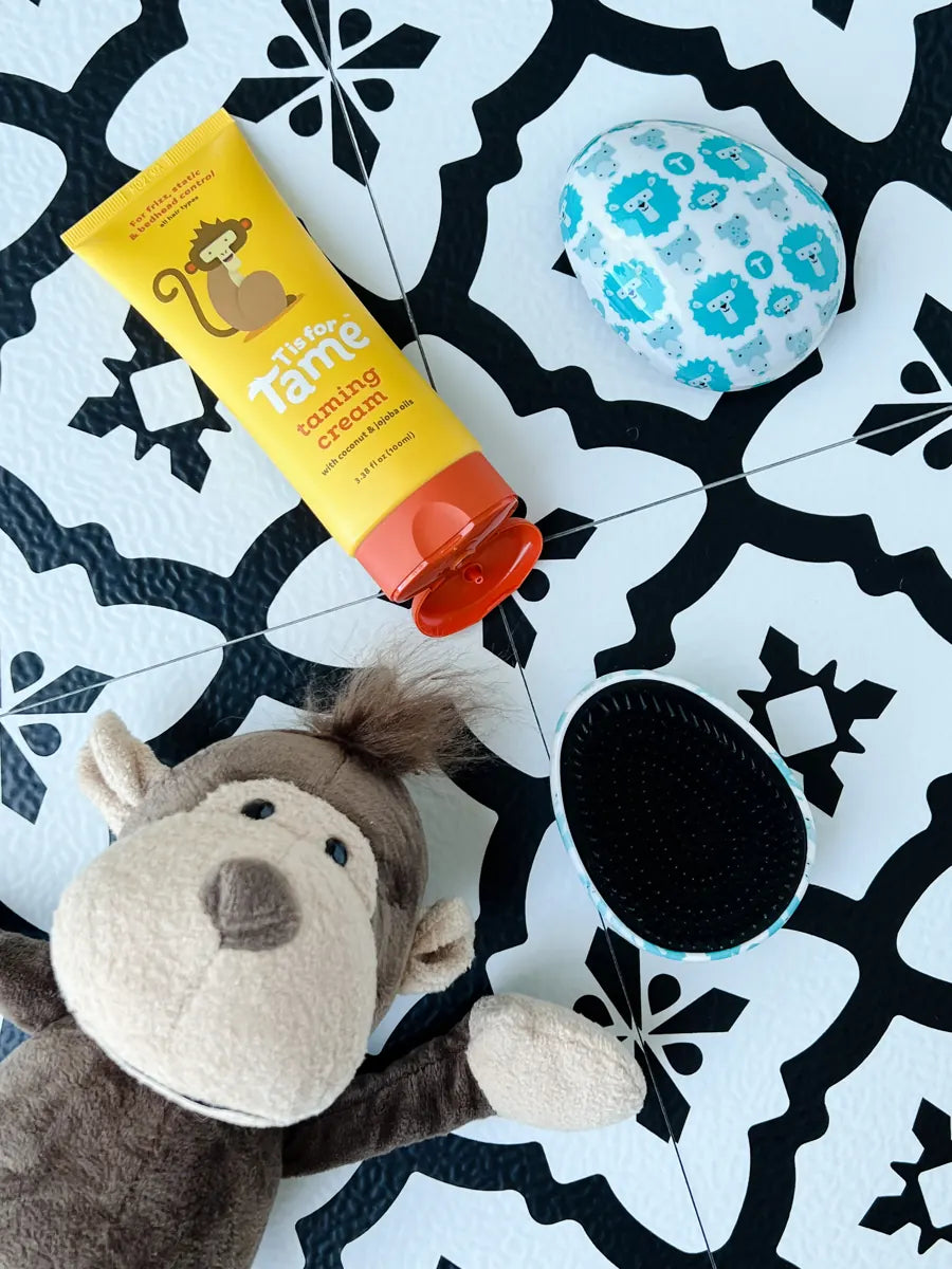 Taming Cream on a patterned tile floor next to the monkey plush and a ScruBEE