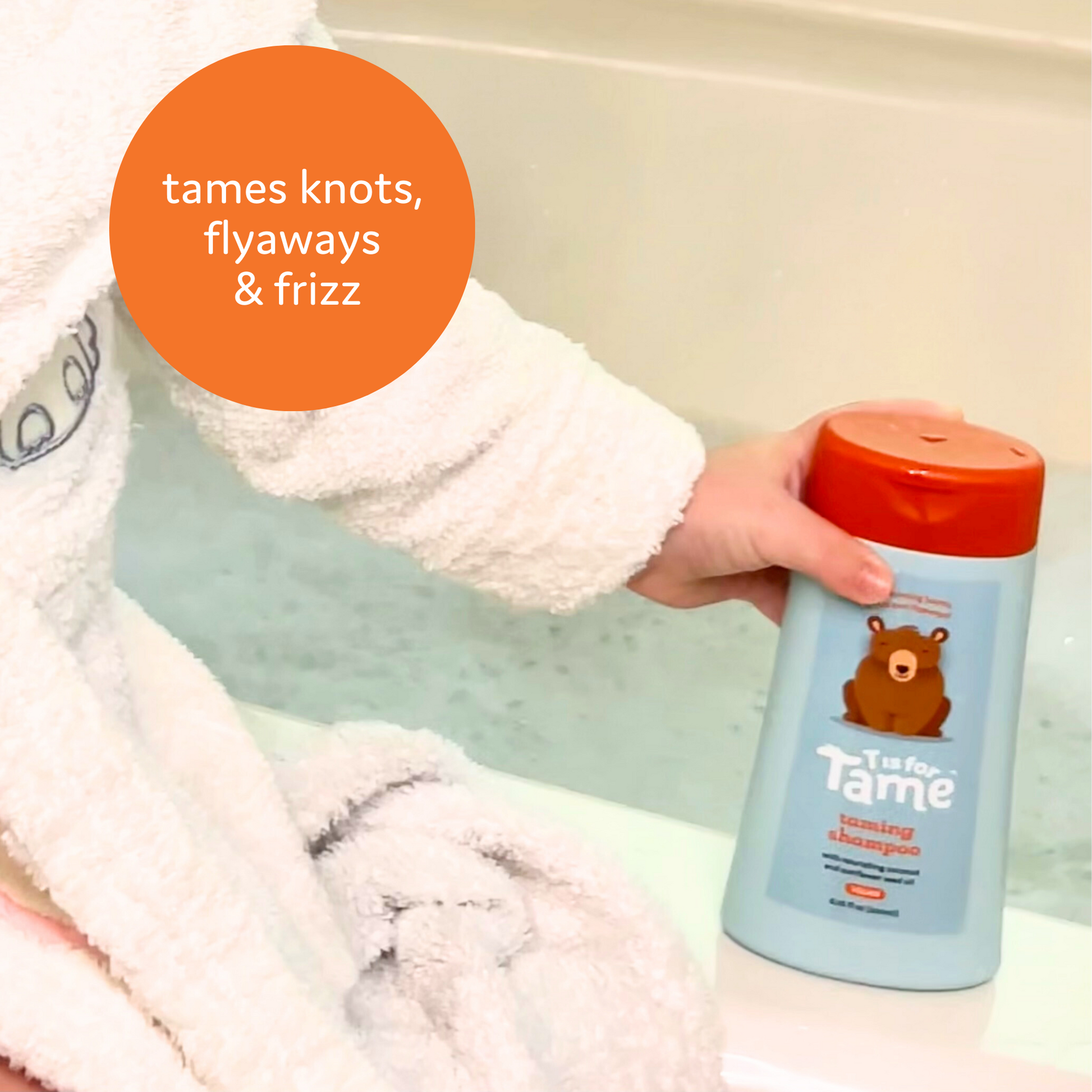 The Taming Shampoo bottle in front of a bath with the tagline: “Tames knots, flyaways, and frizz”