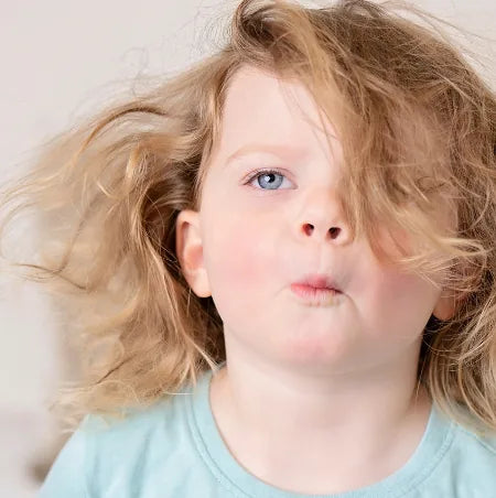 A toddler with tangled bedhead