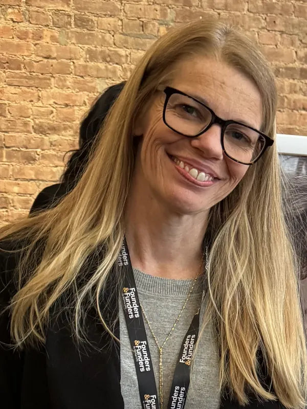 Becky Bavli, founder of T is for Tame, smiling at a T is for Tame table